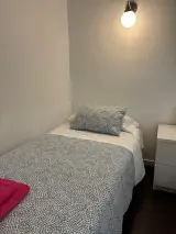 Televisor en escritorio blanco, aire acondicionado y ventana con radiador en la Habitación Doble Confort
